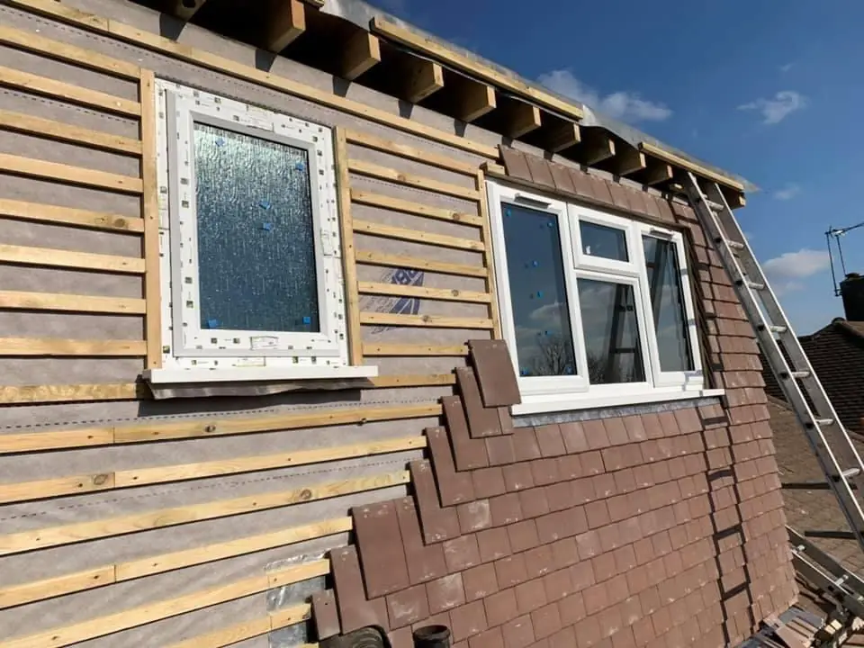 A dormer with new windows fitted and tile hanging started
