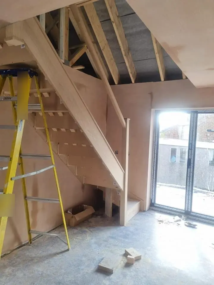 A new oak staircase rising into the framed roof space